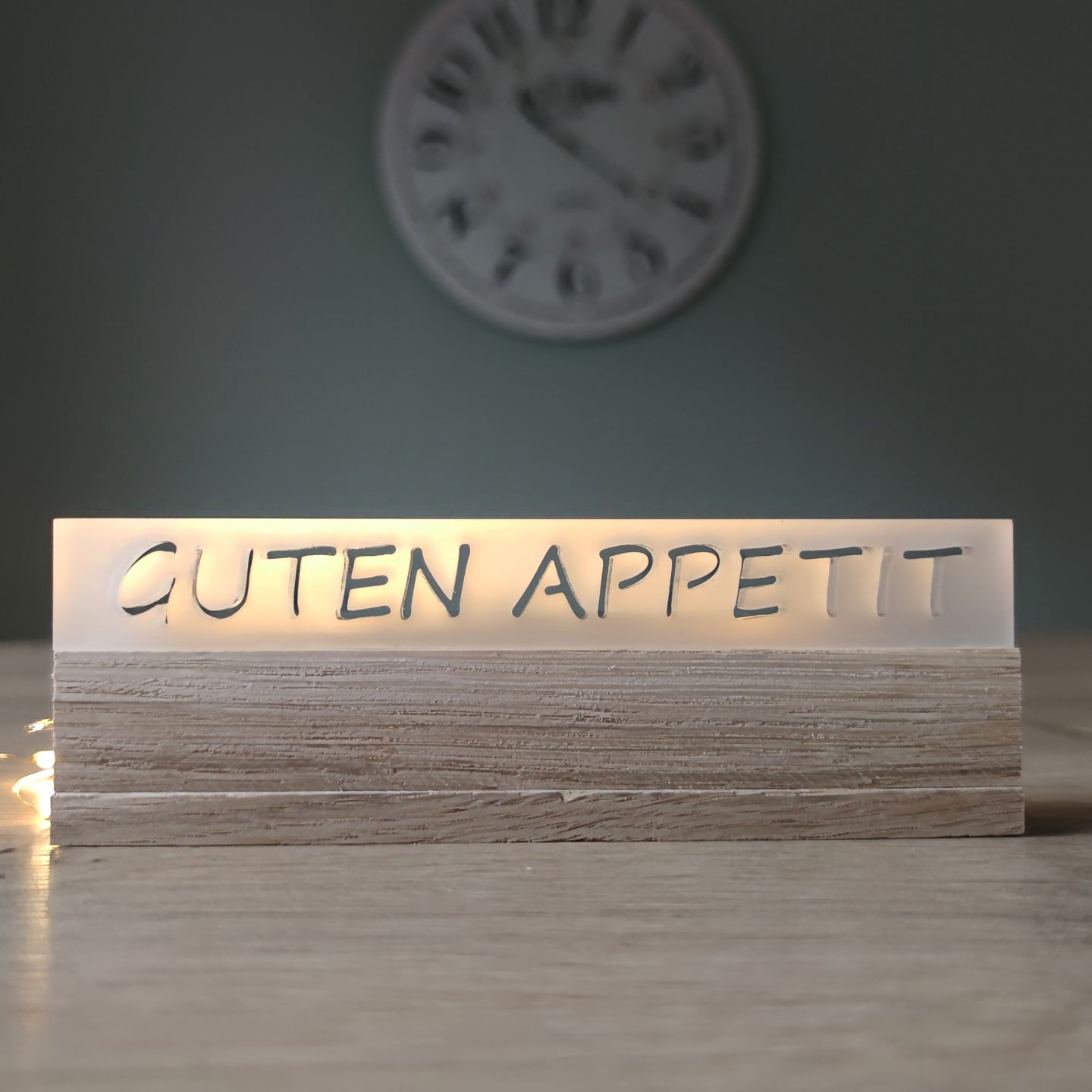 Kreatives Acrylschild von Easy-Sticks mit der Aufschrift GUTEN APPETIT, beleuchtet und elegant auf einem Holztisch präsentiert.