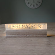 Beleuchteter Acrylschriftzug 'LIEBLINGSORT' auf einem Holzsockel, ideal für Dekoration. Easy-Sticks Acryl Satiniert.