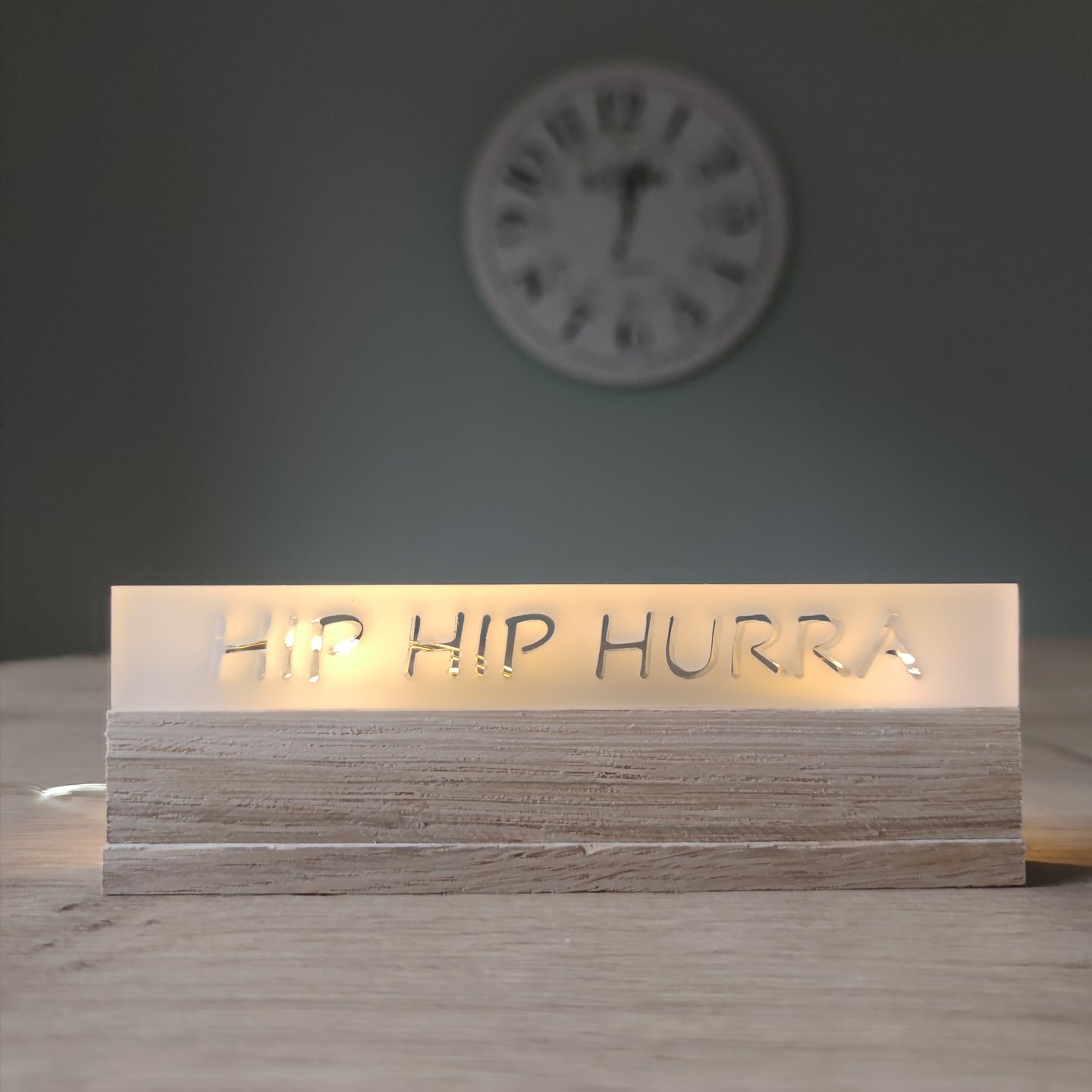Sapf auf einem Tisch mit dem Schriftzug 'HIP HIP HURRA' aus satiniertem Acryl von Easy-Sticks, ideal für Feierlichkeiten und besondere Anlässe.