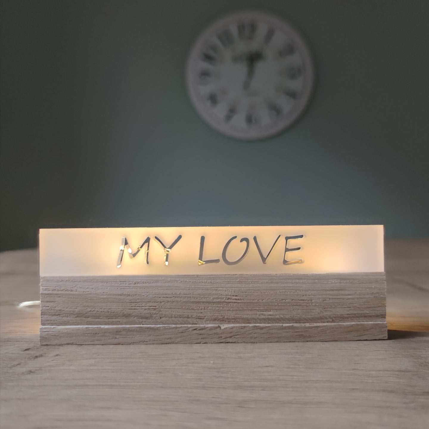 Eine stilvolle Acrylleuchte von Easy-Sticks mit dem Schriftzug 'MY LOVE'. Die Leuchte hat eine satinierte Oberfläche und befindet sich auf einem Holzständer, ideal für romantische Dekoration.