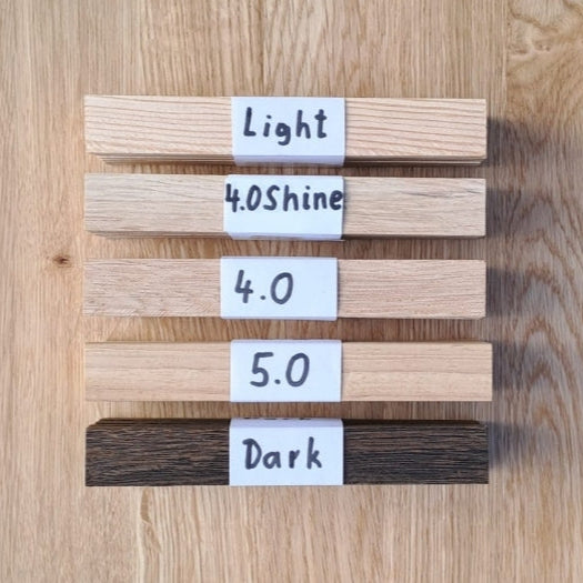 Easy-Sticks Muster Set - Ideal zum Kennenlernen: Präsentation von verschiedenen Holzarten Helge Light, 40.0 Shine, 40.0, 5.0 und Dark auf einer Holzoberfläche.