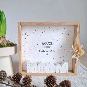 Kreative Glücksbox und Laterne von easy-sticks, gestaltet mit minimalistischem Design, weißen Häuschen und dem Schriftzug 'GLÜCK ist die Summe schöner Momente' auf speckled Hintergrund.