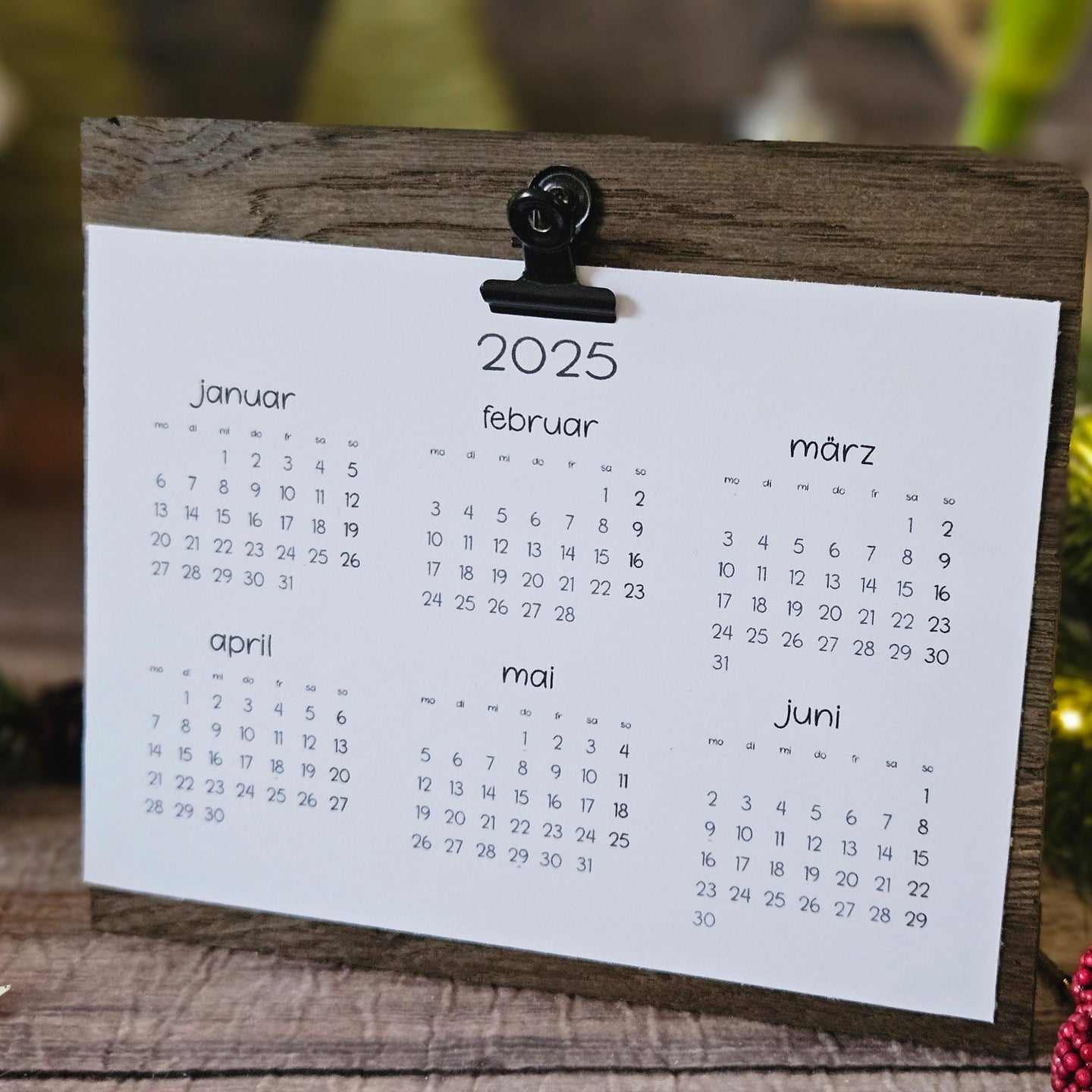 Der kompakte DIY Kalender 2025 von easy-sticks, präsentiert mit einer minimalistischen Klammer und einem natürlichen Holzrahmen, perfekt für den Schreibtisch und um besondere Momente festzuhalten.