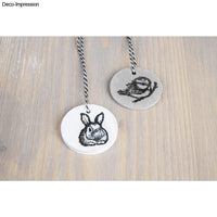 Zwei runde Anhänger aus der Silikon Gießform Mini-Anhänger von easy-sticks, verziert mit einem Hasen und einem Vogelmotiv.