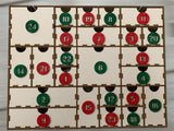 Bunter 3 mm Adventskalender von easy-sticks mit roter und grüner Nummerierung in den Schubladen, wartet auf persönliche Gestaltung mit Geschenken.