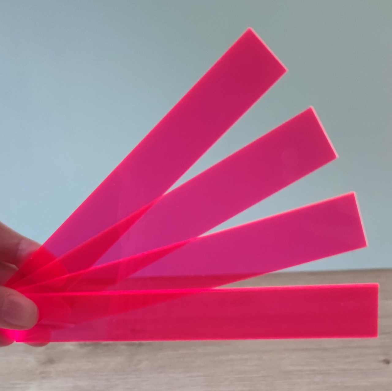 Easy-Sticks Acryl Pink - 4 Stück - 16 cm Länge - Hand hält vier leuchtend pinke Acrylstäbe, ideale Ergänzung für kreative Bastelprojekte von Easy-Sticks.