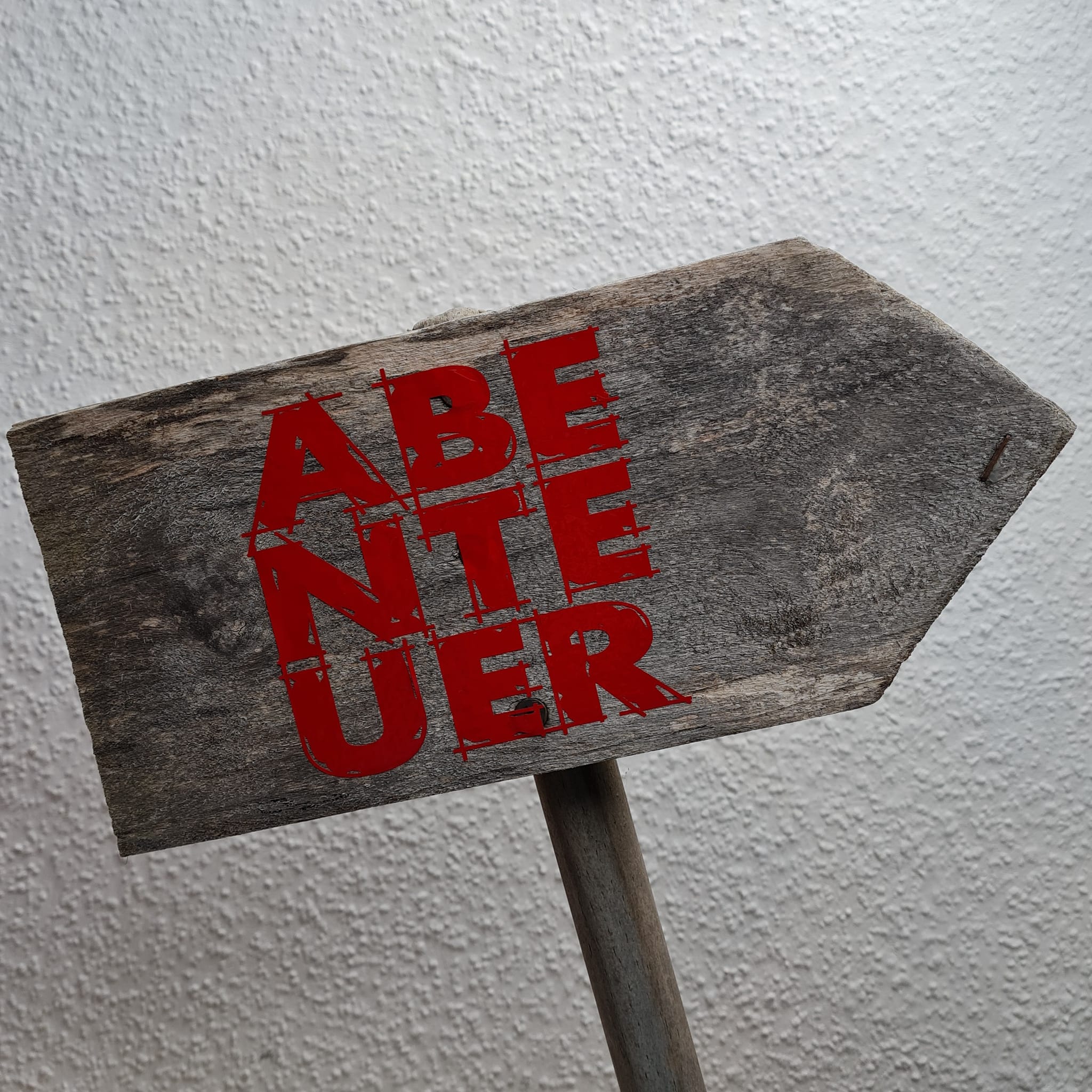 Wegweiser aus Holz mit dem auffälligen Aufdruck 'ABENTEUER' in Rot, inspiriert von der Abenteuer Laserdatei von easy-sticks.