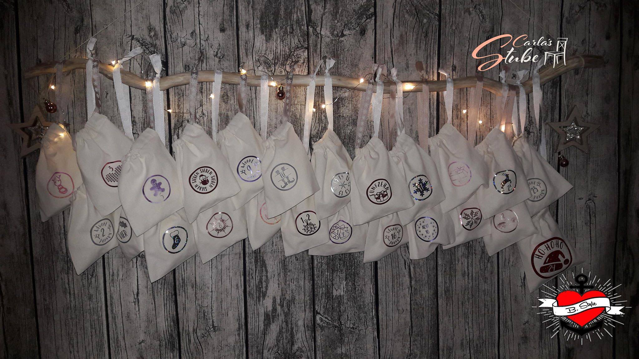 Elegante weiße Adventskalender-Täschchen hängen dekorativ, geziert mit festlichen Symbolen, ideal für Bastelarbeiten von Easy-Sticks. Adventskalender Plotterdatei.