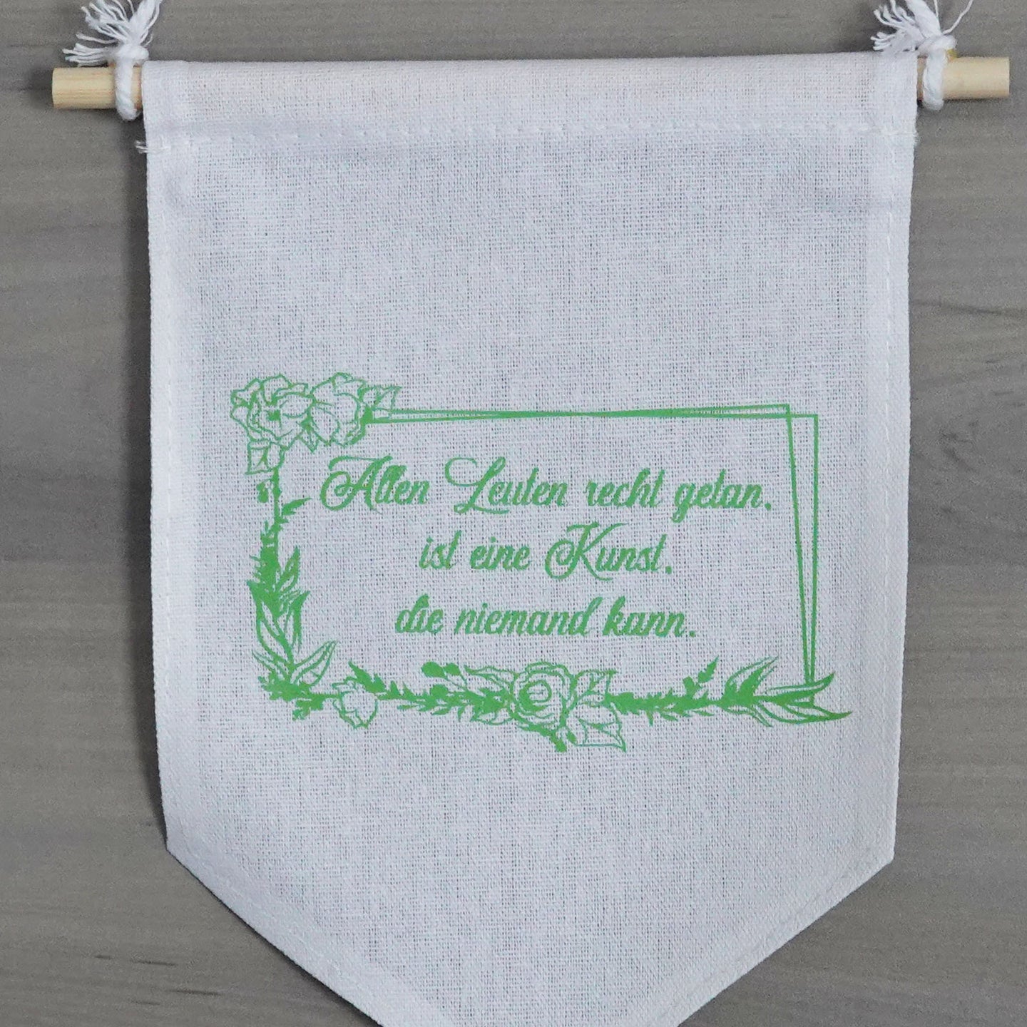 Hochwertige Plotterdatei von easy-sticks mit dem Zitat 'Allen Leuten recht getan, ist eine Kunst, die niemand kann.' auf einem modernen Stoffbanner in sanften Grün- und Brauntönen, perfekt für kreative Anwendungen.