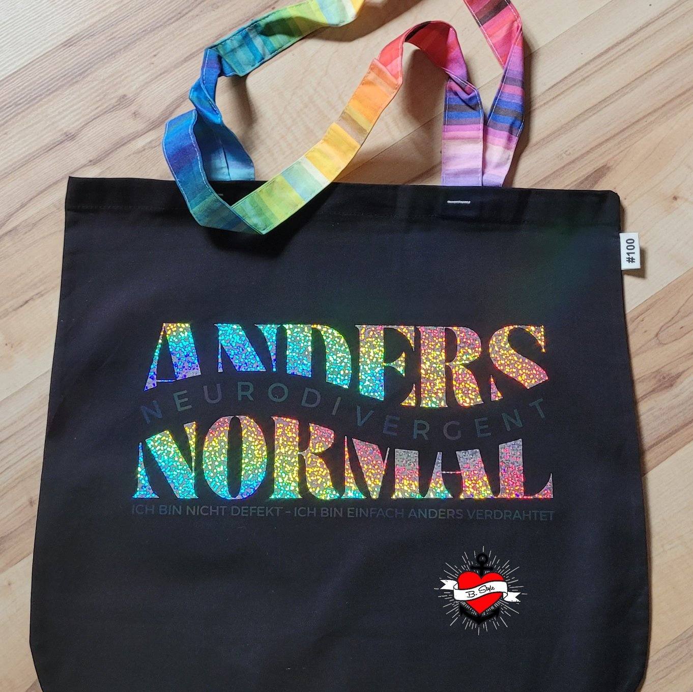 Bunte Tragetasche mit glitzernden Aufdruck "Anders Normal Neurodivergent Ich bin nicht defekt - Ich bin einfach anders verdrahtet" von Easy-Sticks. Perfekt für kreative und individuelle Auftritte.