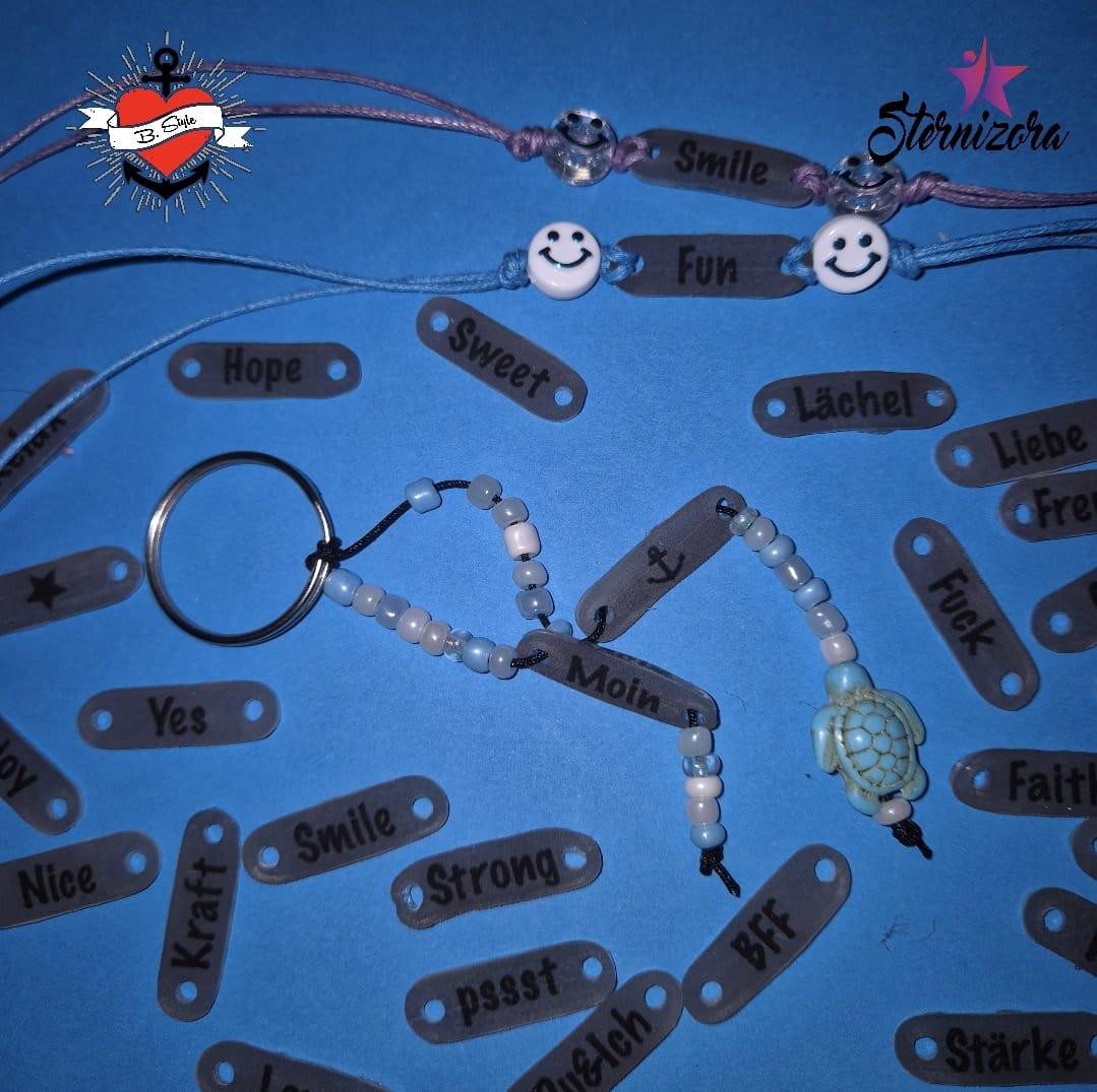 Vielfältige Armbänder und Schlüsselanhänger mit lächelnden Gesichtern und inspirierenden Worten, die aus der Anhänger Teilchen Plotter- und Laserdatei von easy-sticks erstellt wurden.