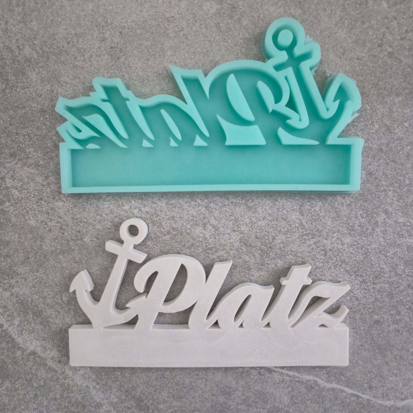 Easy-Sticks Einschieber Silikonform Ankerplatz – Die flexible Silikonform von Easy-Sticks zeigt den Schriftzug 'Ankerplatz' in einer kombinierten Darstellung von mintgrünem und weißem Silikon. Ideal für kreative DIY-Projekte und individuelle Geschenke.