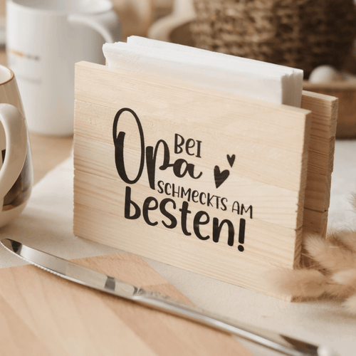 Schöner Serviettenhalter aus Holz mit dem Spruch 'Bei Opa schmeckts am besten!' von easy-sticks, ideal für kreative Bastelprojekte und Heimdekoration.