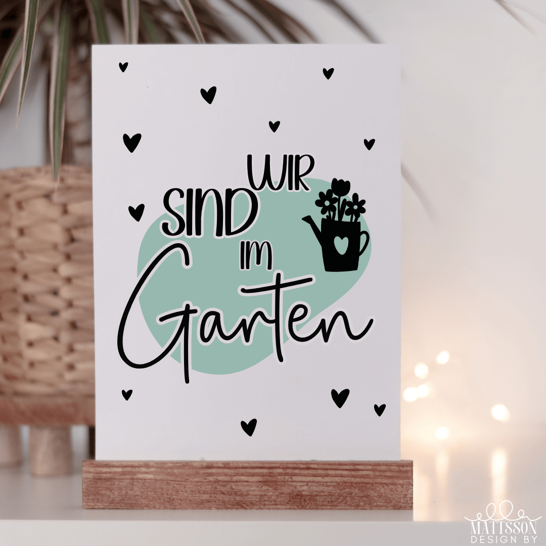 Kunstvolle Dekoration mit Gartenmotiven aus dem Gartenliebe Bundle von easy-sticks: Der Schriftzug 'Wir sind im Garten' auf einem stilvollen Hintergrund.