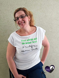 Eine stilvolle Person trägt ein T-Shirt mit der Plotterdatei "Einst schrieb mal ein weiser Arzt" von easy-sticks, welches die kreative Verwendung der Plotterdatei zeigt.