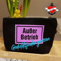 Schminktäschchen mit der "Außer Betrieb - Geduldsfaden gerissen" Laserdatei von easy-sticks, verziert mit glitzerndem lila Hintergrund und türkisfarbener Schrift.