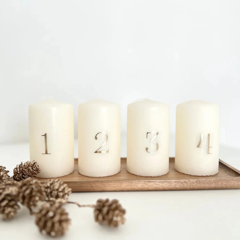 Vier weiße Kerzen mit metallischen Zahlen 1 bis 4, perfekt dekoriert mit der easy-sticks 2in1 Metallic Folie für kreative Dekoideen. Klassisches Design für eine stilvolle Atmosphäre.
