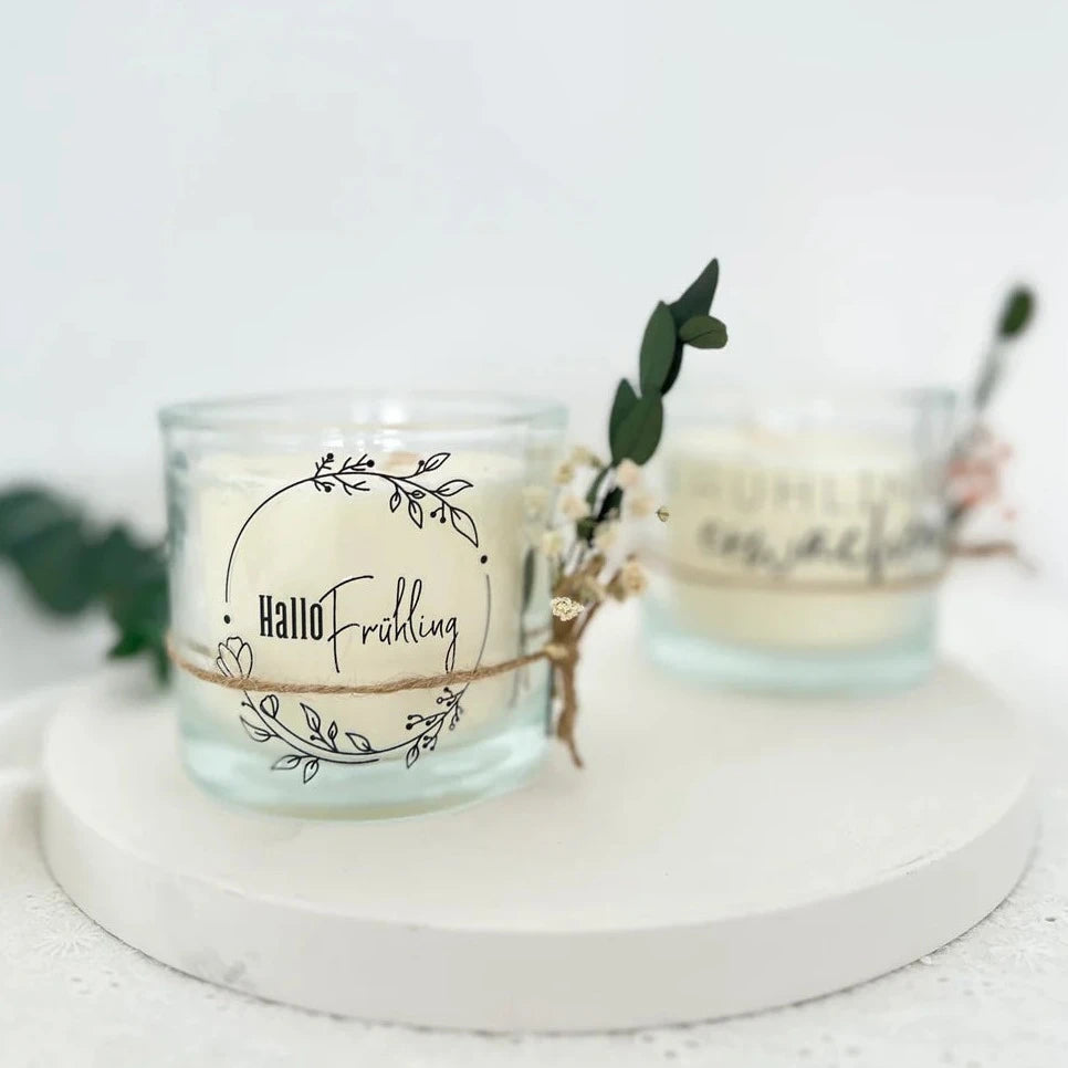 Rub on UV Sticker randlos Zuhause A5 von easy-sticks, dekoriert auf einem zarten Kerzenhalter mit floralen Designs und dem Schriftzug 'Hallo Frühling'.