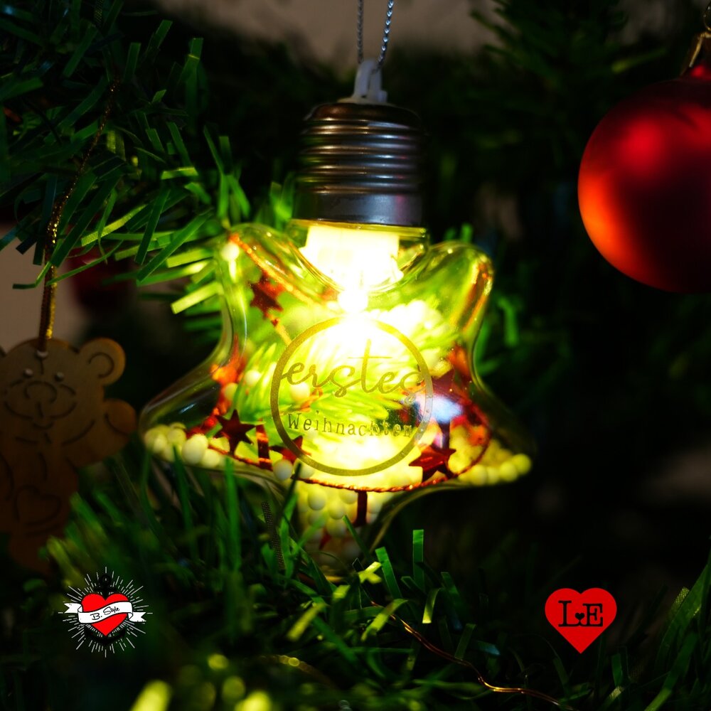 Wunderschöne Baby Meilensteine von easy-sticks: Ein leuchtendes Weihnachtsornament mit dem Text ‚erstes Weihnachten‘, perfekt für festliche DIY-Projekte.