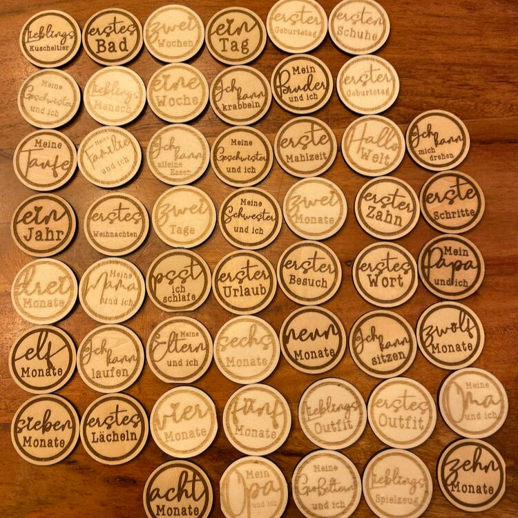Eine Sammlung von Laser- und Plotterdateien für Baby Meilensteine von easy-sticks, die kreative gepresste Holzmarken mit Meilensteinen wie "erstes Bad" und "zehn Monate" zeigen.