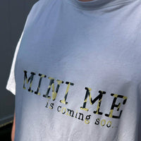 Mann trägt ein T-Shirt mit dem Aufdruck "MINI ME is coming soo...". Dieses Bild betont die Vorfreude auf das neue Familienmitglied und ist perfekt für kreative Schwangerschaftsprojekte mit der Babybauch Plottersprüche Datei von easy-sticks.