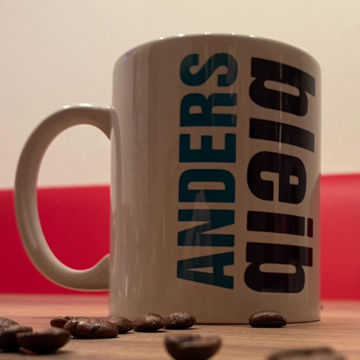 Kaffeetasse mit dem Aufdruck "bleib ANDERS" von easy-sticks, dekoriert mit Kaffeebohnen.