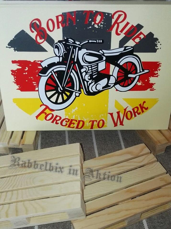 Motorrad-Grafik mit dem Text "Born to Ride - Forced to Work" auf einem Holzschild, umgeben von bearbeiteten Holzstücken. Entworfen von Easy-Sticks für kreative Plotterprojekte.