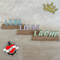 Drei Buchstaben Aufsteller mit den Worten 'LEBE', 'LIEBE' und 'LACHE', stilvoll arrangiert als kreative Deko, erstellt mit Easy-Sticks Plotterdatei.