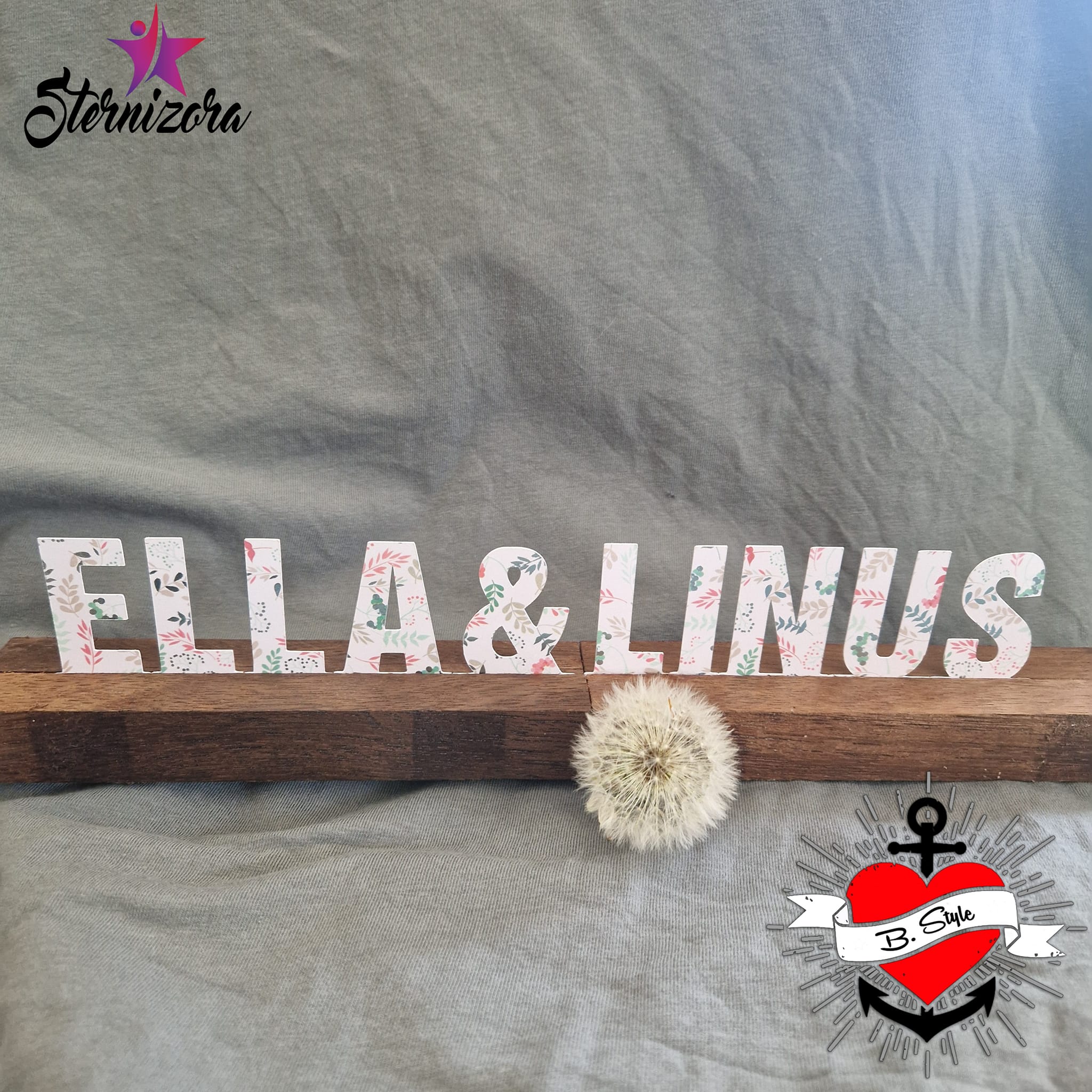 Kreative Buchstaben und Zahlen Aufsteller von Easy-Sticks, die den Namen 'ELLA & LINUS' darstellen, auf einem Holztisch mit einer dekorativen Dandelion-Pflanze und einem stilvollen Logo von B.Style.