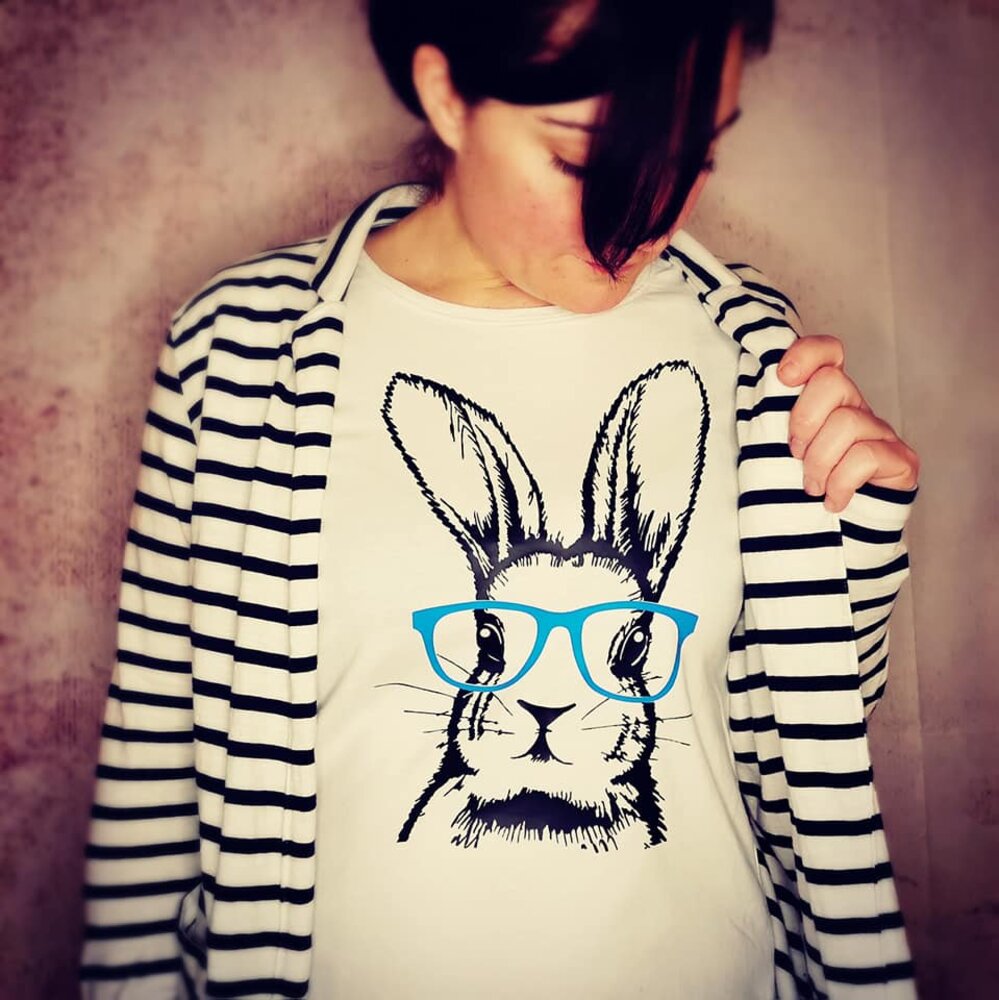 Frau trägt ein T-Shirt mit dem Bunny Hasen Design von easy-sticks, das einen stilisierten Hasen mit blauen Brillengläsern zeigt.