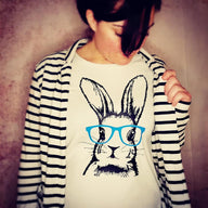 Frau trägt ein T-Shirt mit dem Bunny Hasen Design von easy-sticks, das einen stilisierten Hasen mit blauen Brillengläsern zeigt.
