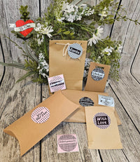 Ein liebevoll arrangiertes Set aus verschiedenen Geschenktüten und Etiketten, bedruckt mit Phrasen wie 'Danke', 'Unikat' und 'Handmade', perfekt für DIY-Projekte – Button Plotterdatei von easy-sticks.
