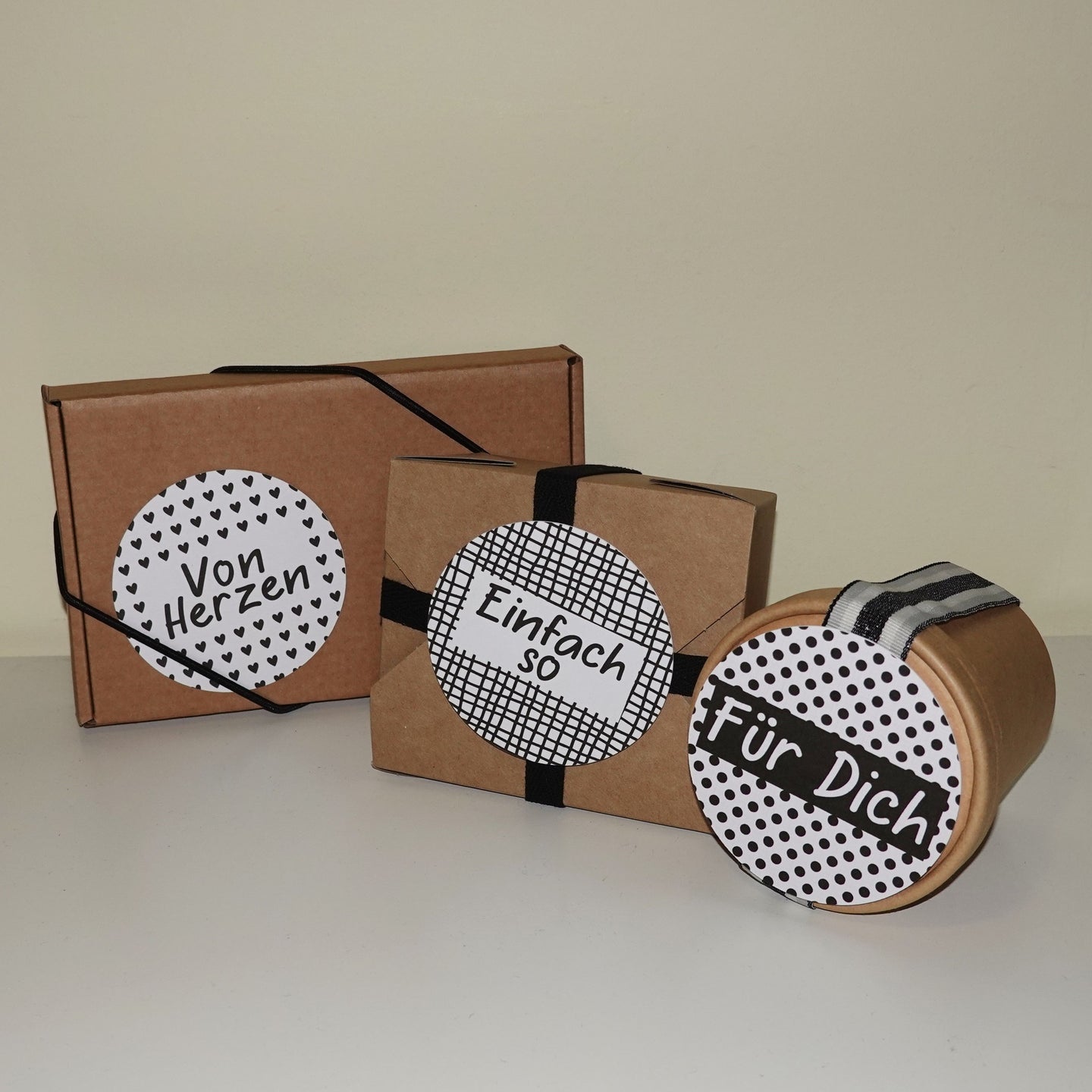Verpackungen mit individuellen Etiketten aus der Button Plotterdatei von easy-sticks, die eigenständig gestaltete Botschaften wie 'Von Herzen' und 'Einfach so' zeigen.