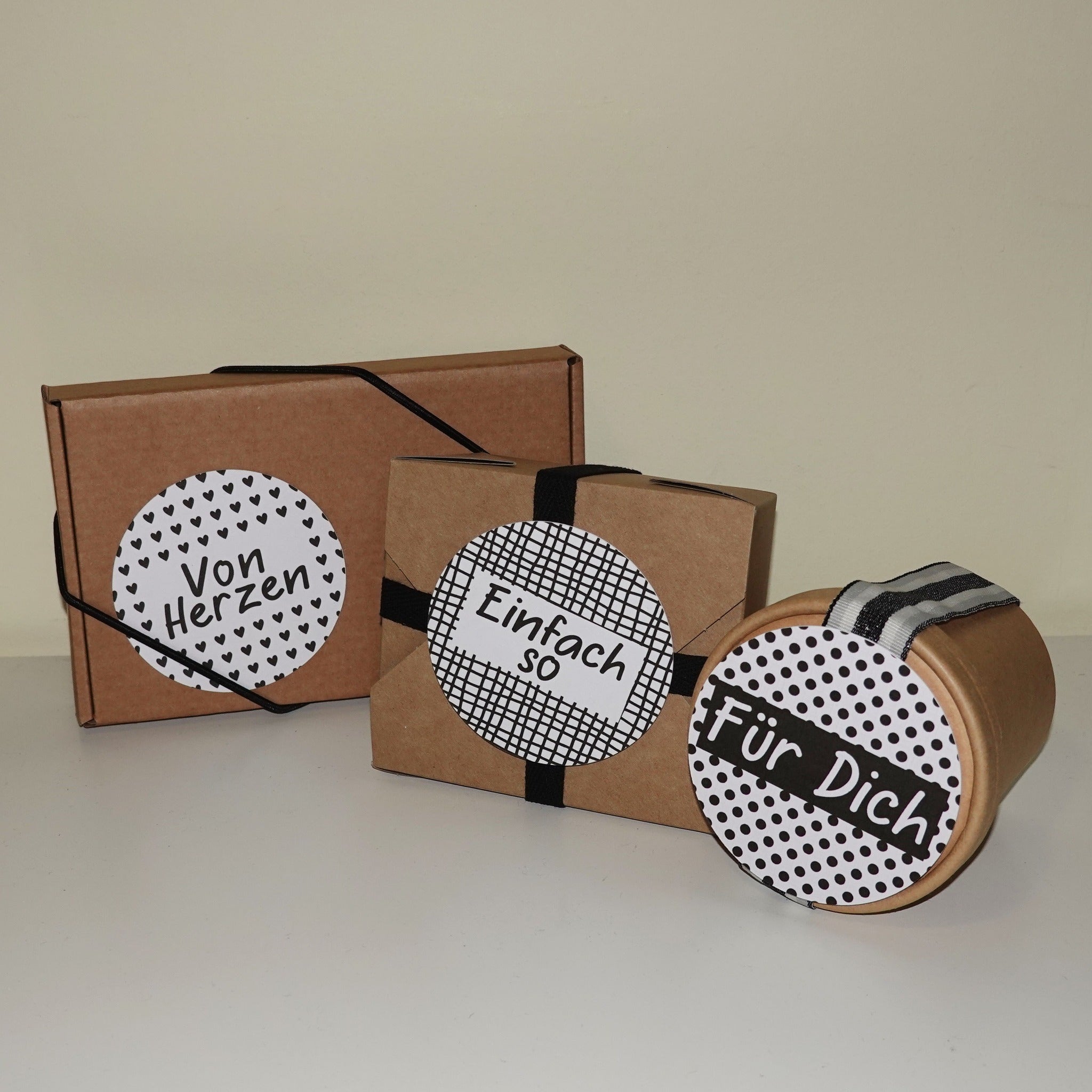 Verpackungen mit individuellen Etiketten aus der Button Plotterdatei von easy-sticks, die eigenständig gestaltete Botschaften wie 'Von Herzen' und 'Einfach so' zeigen.