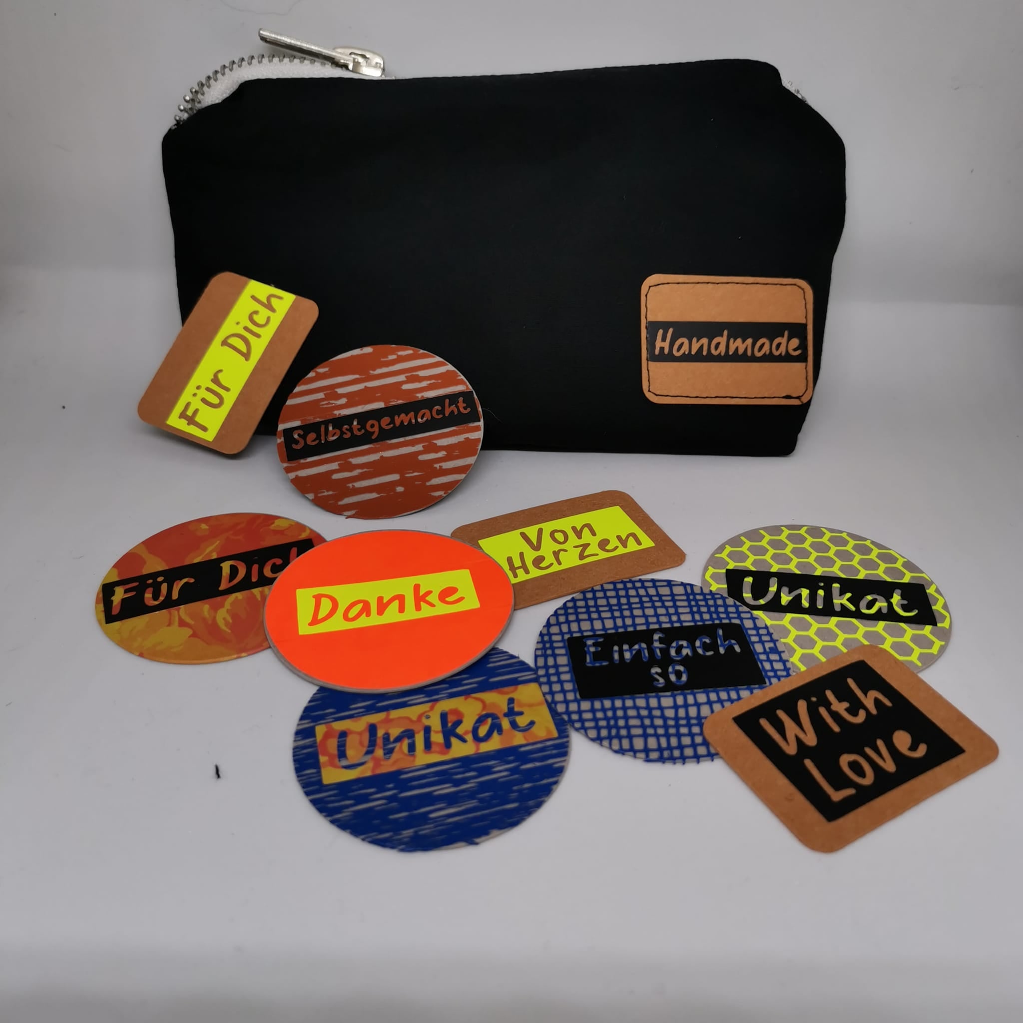 Farbenfrohe Labels und Aufkleber, erstellt mit der Button Plotterdatei von easy-sticks, die vielseitige Designs wie 'Danke', 'Unikat', und 'Selbstgemacht' präsentieren.