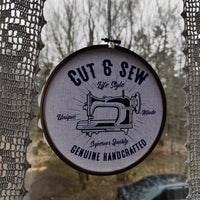 Kreatives Wanddesign mit dem 'Cut & Sew' Schriftzug und einer Nähmaschine, dekoriert in einem Rahmen. Digitales Produkt von easy-sticks.