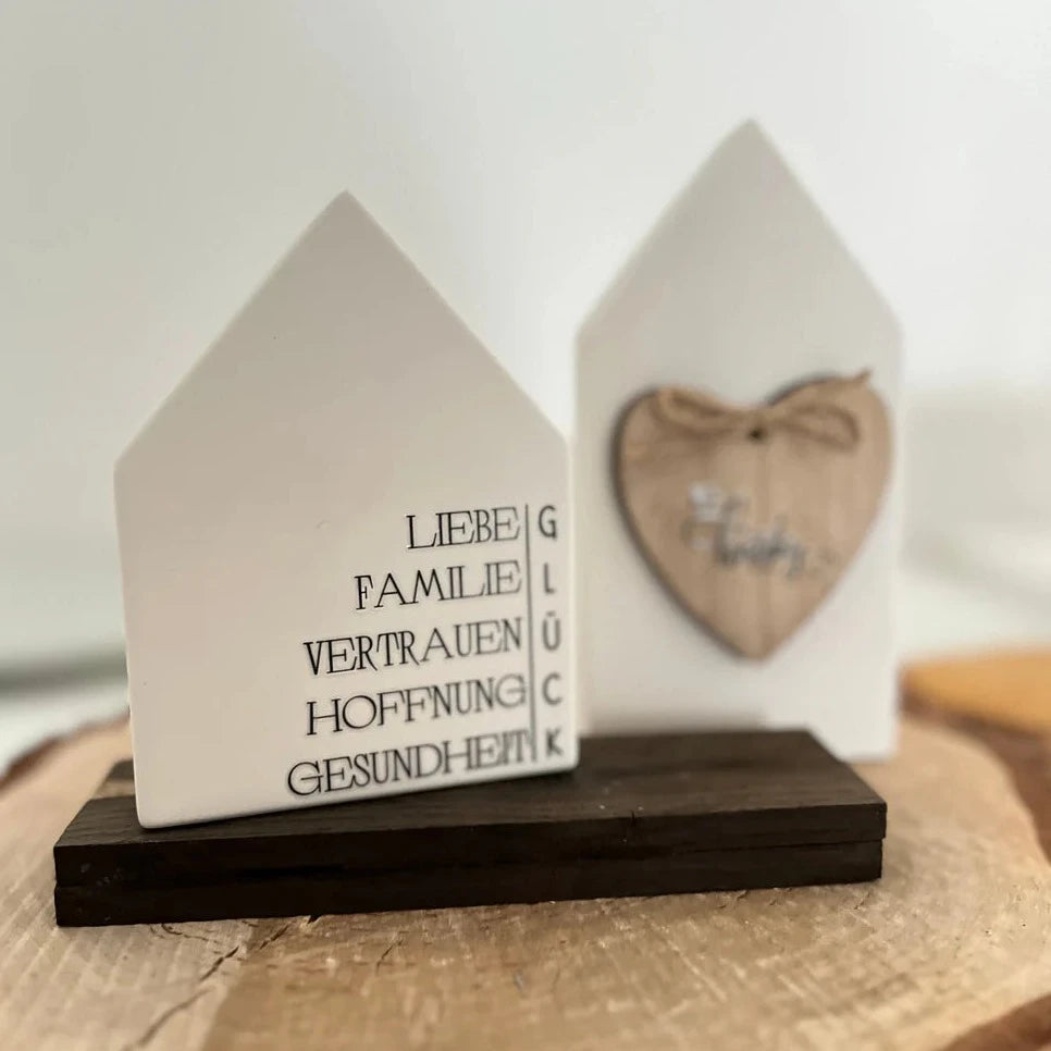 Zwei charmante Deko-Häuser mit den Inschriften 'LIEBE, FAMILIE, VERTRAUEN, HOFFNUNG, GESUNDHEIT' und 'GLÜCK', erhältlich bei easy-sticks.