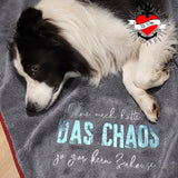Ein wunderschöner Hund auf einer Decke mit dem Aufdruck 'DAS CHAOS', designt von easy-sticks. Ideal für Haustierliebhaber!