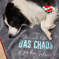 Ein wunderschöner Hund auf einer Decke mit dem Aufdruck 'DAS CHAOS', designt von easy-sticks. Ideal für Haustierliebhaber!