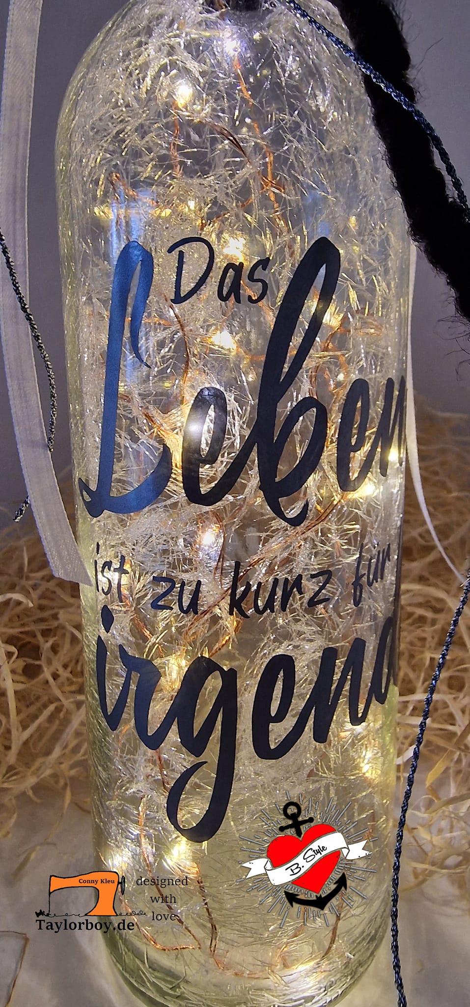 Beleuchtete Flasche mit der Plotterdatei "Das Leben ist zu kurz für irgendwann" von easy-sticks, die ein kreatives Ambiente schafft.