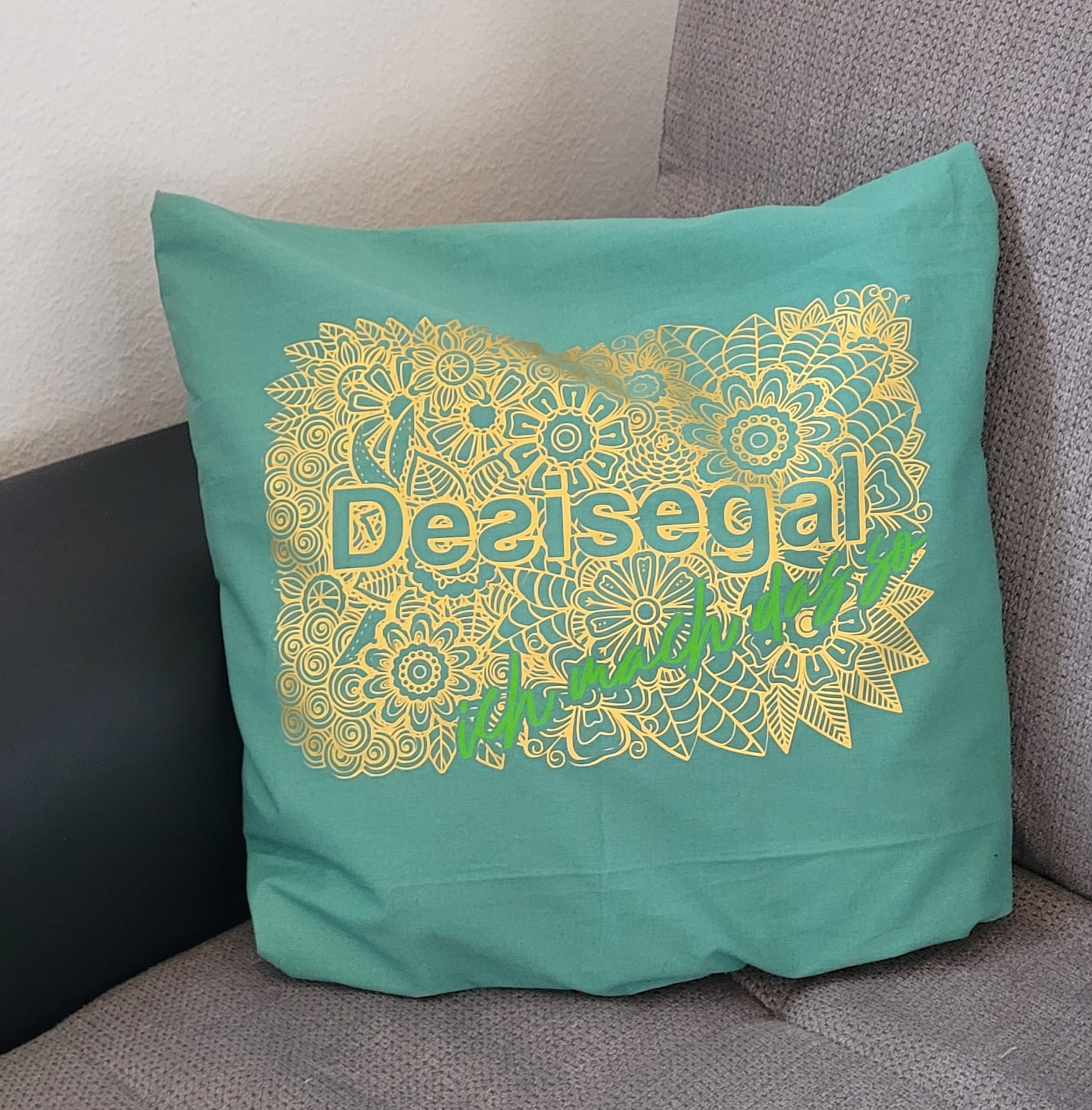Türkisfarbenes Kissen mit goldenem Mandala-Motiv und dem Schriftzug 'Desisegal ich mach das so', gestaltet von easy-sticks.