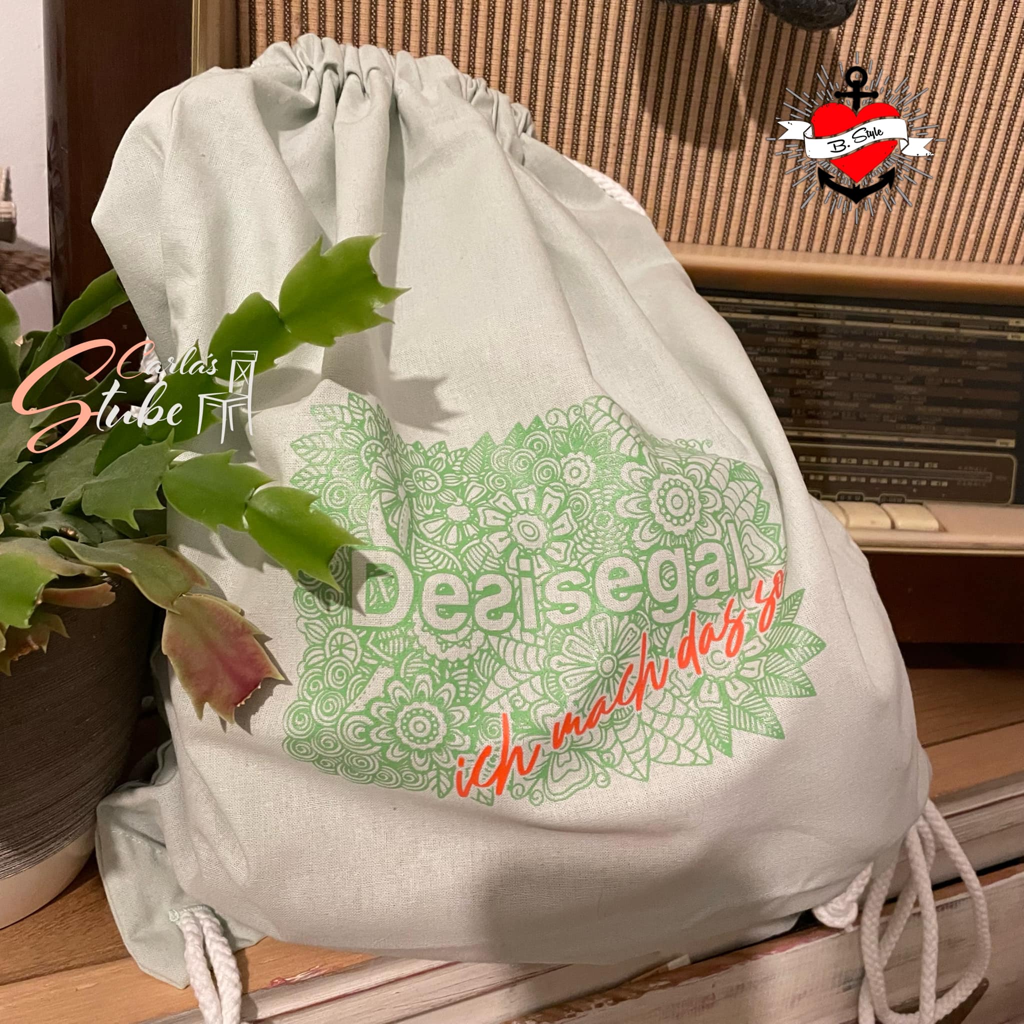 Schöner Stoffbeutel mit der Aufschrift "Desisegal ich mach das" auf einem Vintage-Tisch, künstlerisch dekoriert und ideal für kreative Projekte mit den Plotterdateien von easy-sticks.