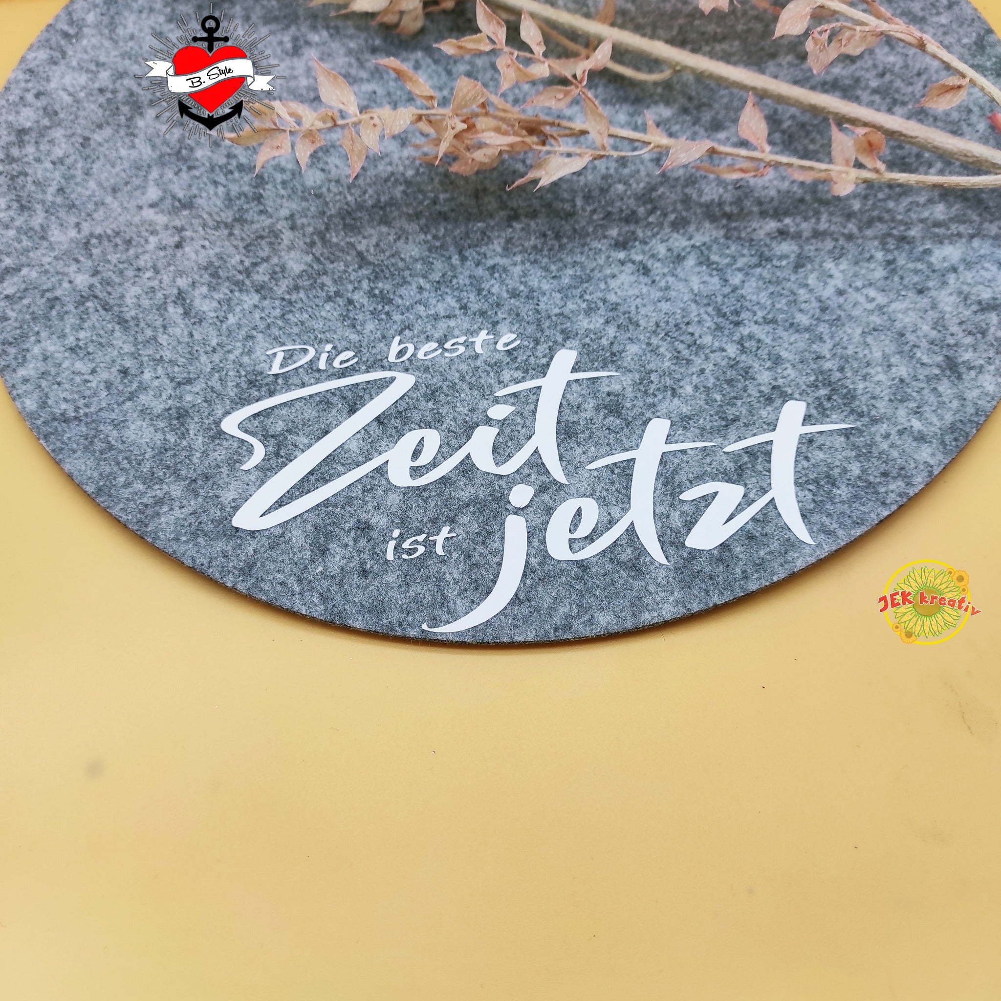 Kreatives Projekt mit der Plotterdatei "Die beste Zeit ist jetzt" von easy-sticks, präsentiert auf einer grauen Unterlage im minimalistischen Stil.