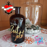 Eine stilvolle Flasche mit dem Aufdruck "Die beste Zeit ist jetzt" von easy-sticks, setzt farbige Akzente und ergänzt jede kreative Dekoration.