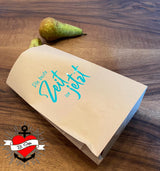 Kreative Verpackungsidee mit der Plotterdatei "Die beste Zeit ist jetzt" von easy-sticks, dekoriert mit einer stilvollen Aufschrift auf Kraftpapier.