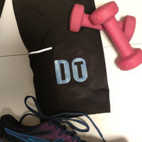 Schwarze Sporthose mit dem Schriftzug 'DT', daneben pinke Hanteln. Ideal für kreative Fitnessprojekte mit der 'DO IT' Plotterdatei von easy-sticks.