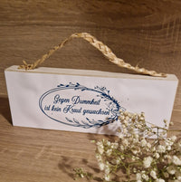 Deko-Schild mit der Aufschrift 'Gegen Dummheit ist kein Kraut gewachsen' von easy-sticks. Ein rustikales Design ergänzt durch eine natürliche Schnur und florale Elemente für kreative Projekte.