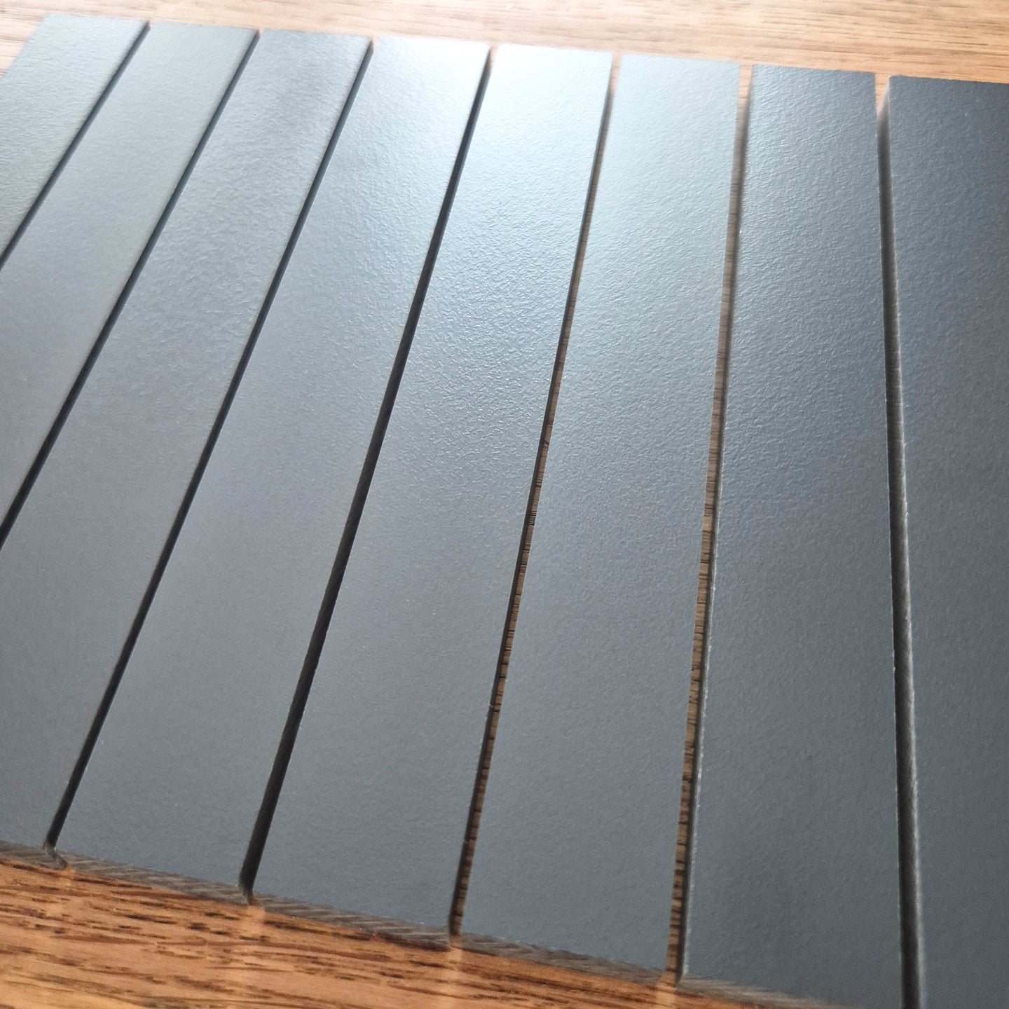 Easy-Sticks HPL Anthrazit von Easy-Sticks, 8 Stück, 16 cm lang, gezeigt in einer eleganten Anordnung auf einem Holzuntergrund, ideal für DIY-Projekte.