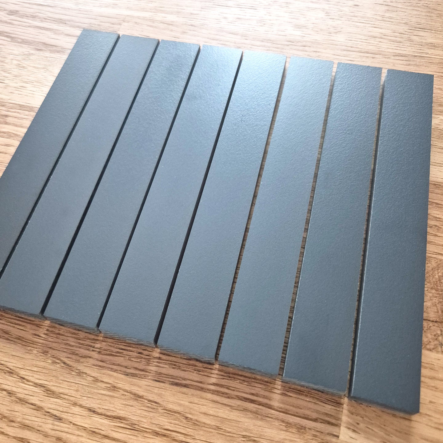 Easy-Sticks HPL Anthrazit von Easy-Sticks, 8 Stück, 16 cm lang, gezeigt in einer eleganten Anordnung auf einem Holzuntergrund, ideal für DIY-Projekte.