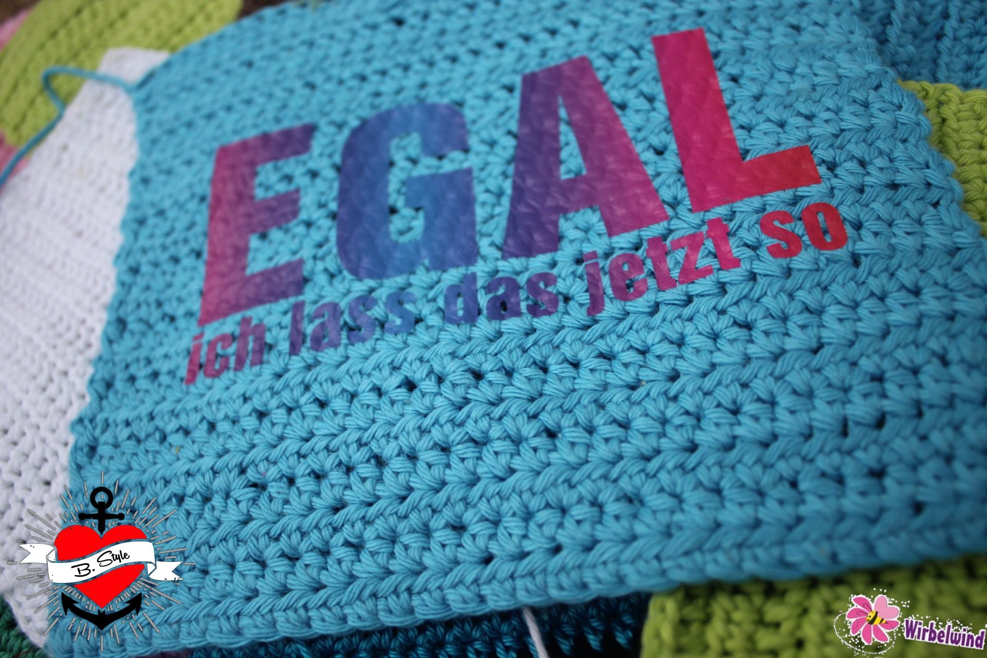 Gekreuzter Handarbeitsartikel in leuchtendem Blau mit 'EGAL ich lass das jetzt so' Aufdruck, inspiriert von der Plotterdatei von easy-sticks - perfekt für kreative Hobbys.